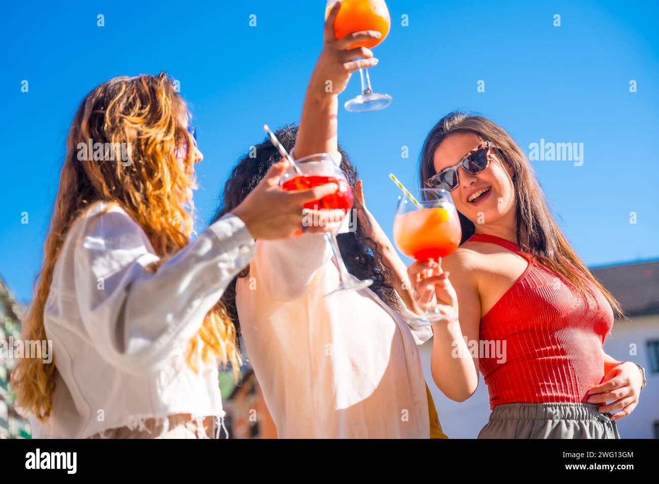 Glückliche Szene von drei Frauen während eines perfekten Sommers mit Freunden, die auf einem Dach feiern Stockfoto