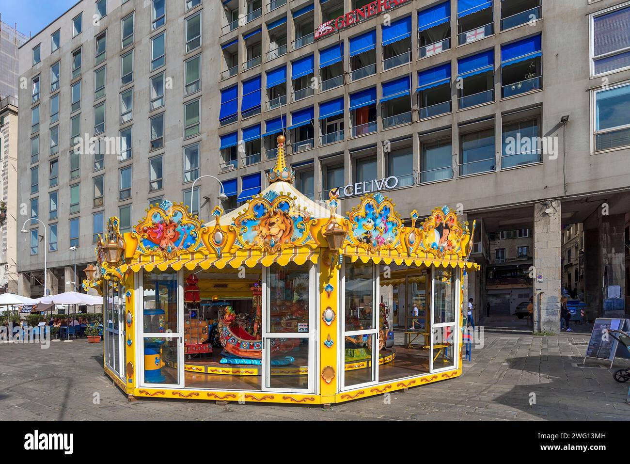 Kinderkarussell mit bemalten Disney-Figuren am alten Hafen, hinter Wolkenkratzern, Genua, Italien Stockfoto