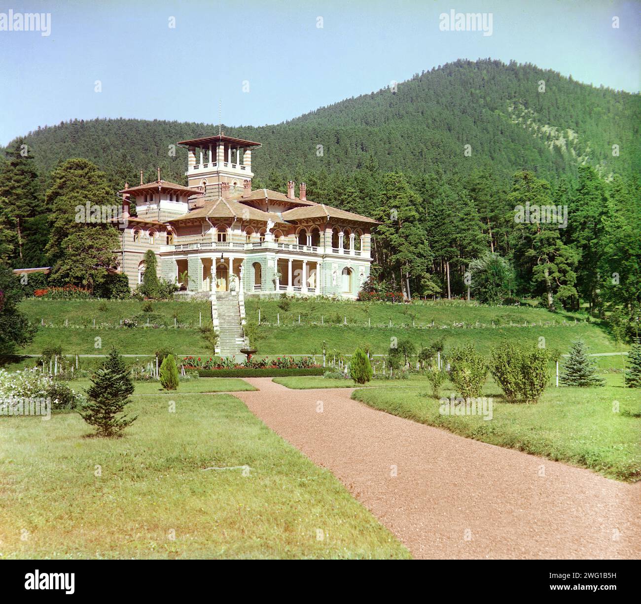 Allgemeiner Blick auf den Likanskii-Palast vom Fluss Kura, zwischen 1905 und 1915. Die Likany-Ausläufer des Kaukasus bieten eine dramatische Kulisse für einen Palast, der am Fluss Kura, nahe der russischen Grenze zur Türkei und nahe der Stadt Borzhomi im heutigen Georgien errichtet wurde. Der Romanov-Palast, auch bekannt als Likani-Palast, wurde von Leon Benois für Großherzog Nikolaus Michailowitsch von Russland entworfen. Stockfoto