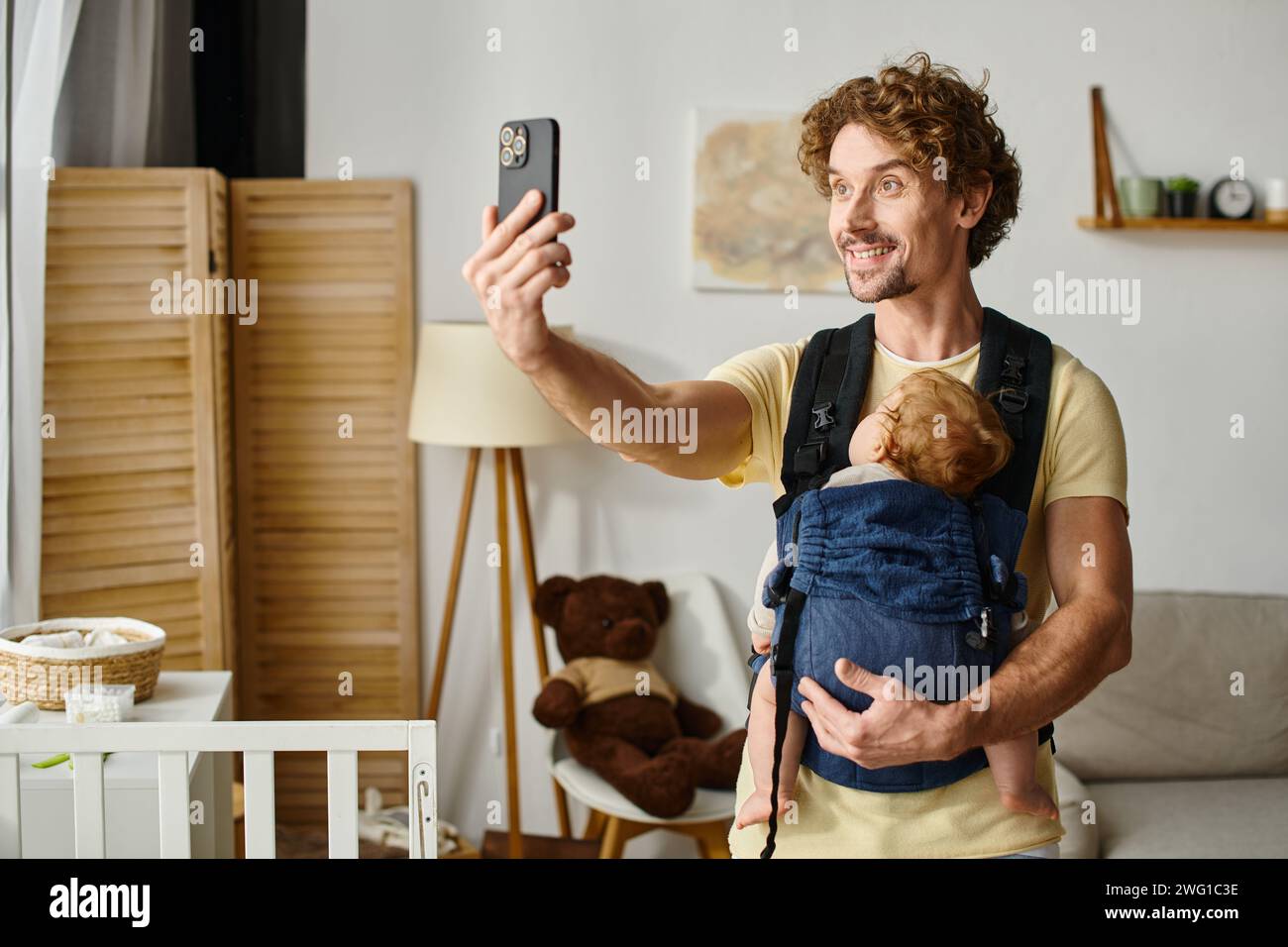 Glücklicher Vater, der Selfie mit schlafendem Baby in Tragetasche, Vaterschaft und modernem Elternkonzept macht Stockfoto