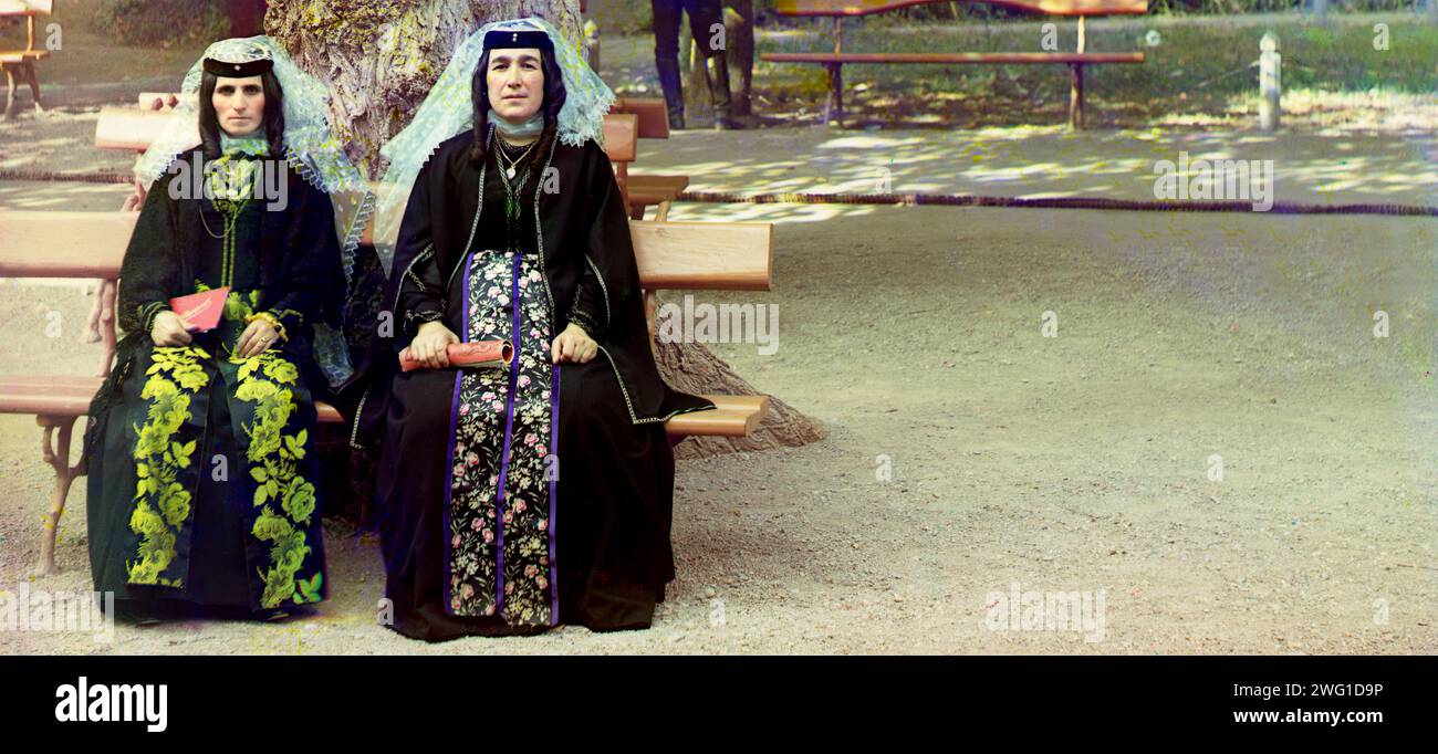 Georgische Frauen in Ferienkleidung im Park von Borzhom (Borjomi, Georgia) zwischen 1905 und 1915. Frauen in traditioneller Tracht - verdeckte Kopfbedeckungen über verdrehten Frisuren, Kleider mit Blumenmuster. Stockfoto