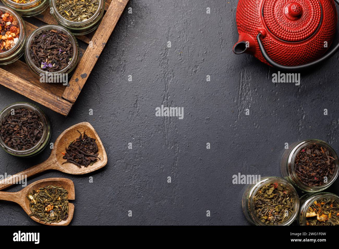 Teezeitsortiment: Verschiedene trockene Teeblätter und Teekanne. Flache Ladefläche mit Kopierraum Stockfoto