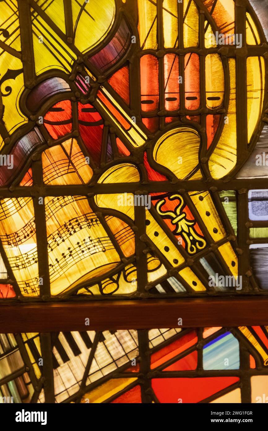 England, Sussex, East Sussex, Seaford, Seaford Museum, Buntglasfenster aus der Kapelle der Petersschule mit Musikinstrumenten Stockfoto
