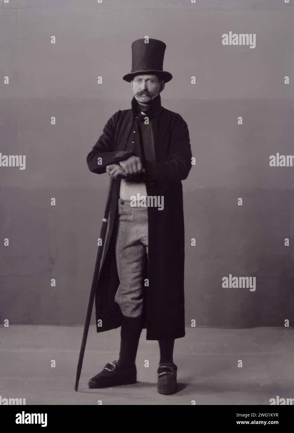 Ein Mann posiert in Volkstracht mit langem Mantel und Hut, 1880-1907. Stockfoto