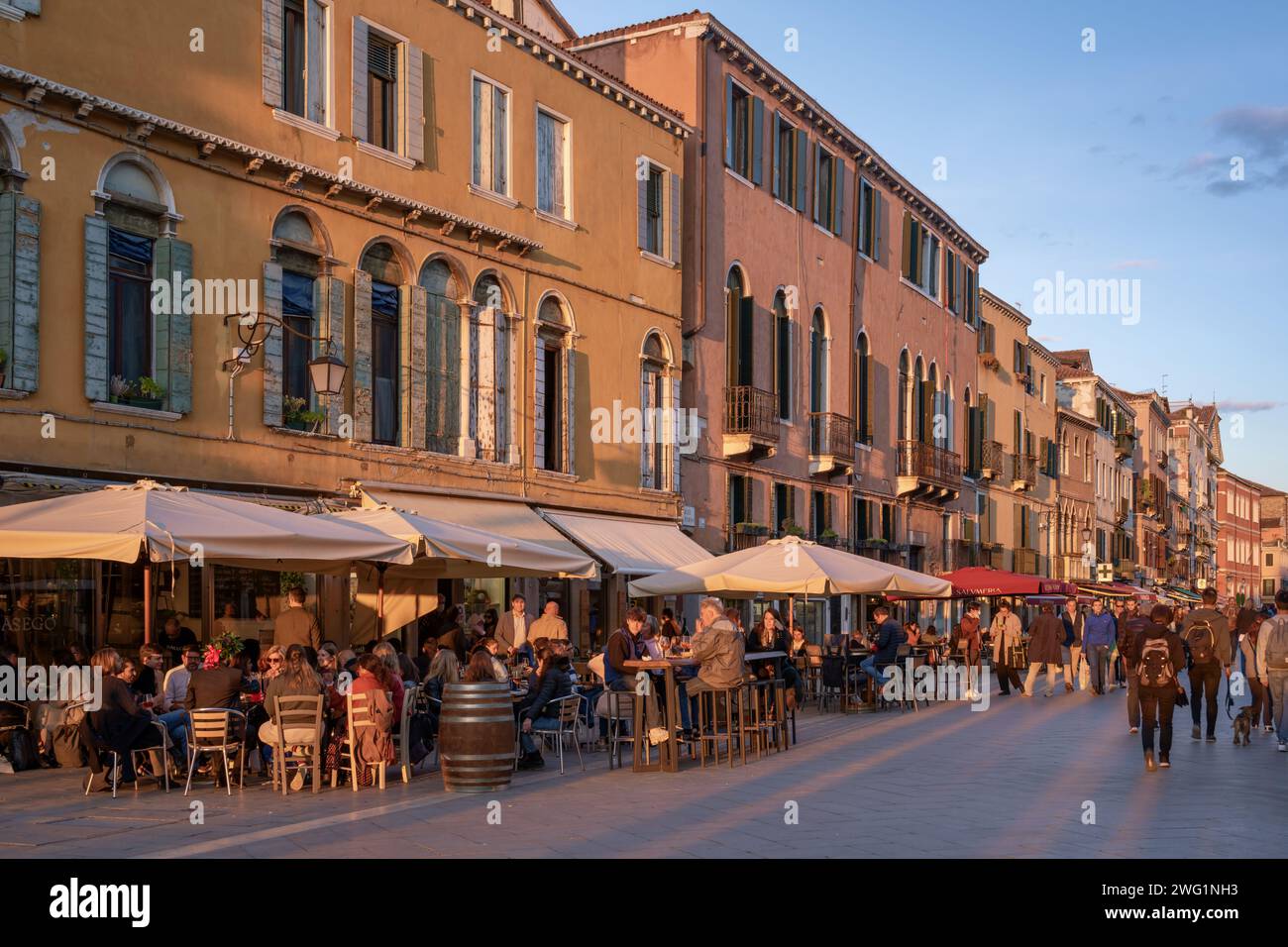 Eine lebhafte Abendszene von Menschenmassen, die im Freien auf Restaurants und Cafés entlang der Via Giuseppe Garibaldi in Venedig, Italien, speisen Stockfoto