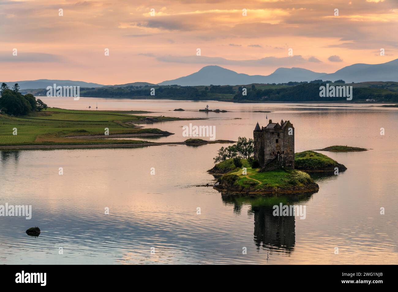 Castle Stalker auf Loch Laich mit Wasserreflexionen bei Sonnenuntergang, Argyll, Schottland, Großbritannien Stockfoto