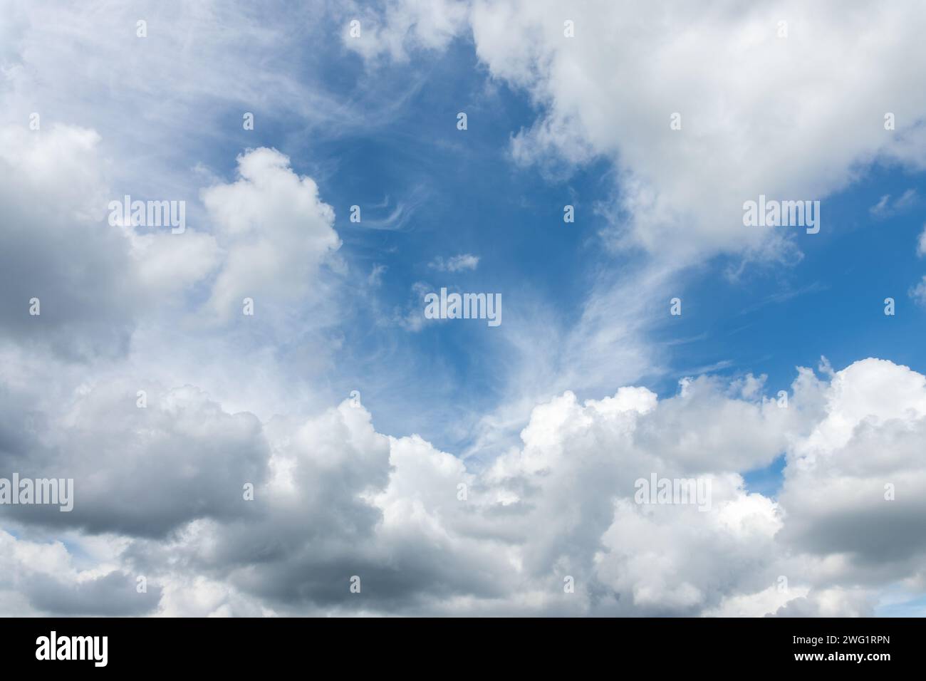 Sonniger blauer Himmel mit wunderschönen leichten, flauschigen Wolken, Tageshimmel Ersatz oder Hintergrund Stockfoto
