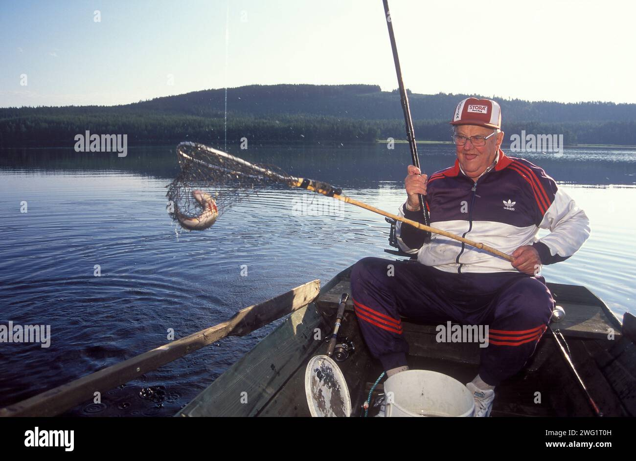 Ein alter Mann fischt vom Ruderboot aus Stockfoto