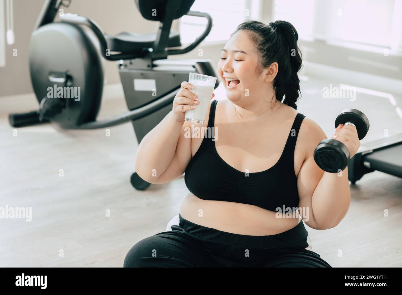 Sport gesunde fette Frauen glückliches Lächeln Genießen Sie trinken Milch und Diät Übung Aktivität in Fitness Sport Club Stockfoto