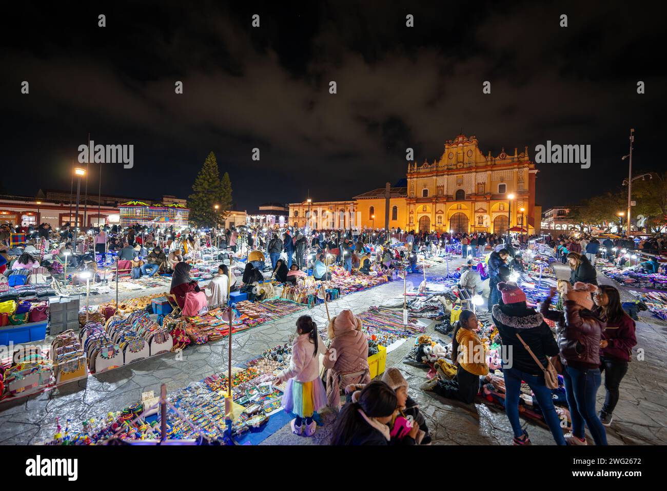 Die überfüllte Marktstraße bei Nacht mit Catedral de San Cristobal de las Casas im Hintergrund Stockfoto