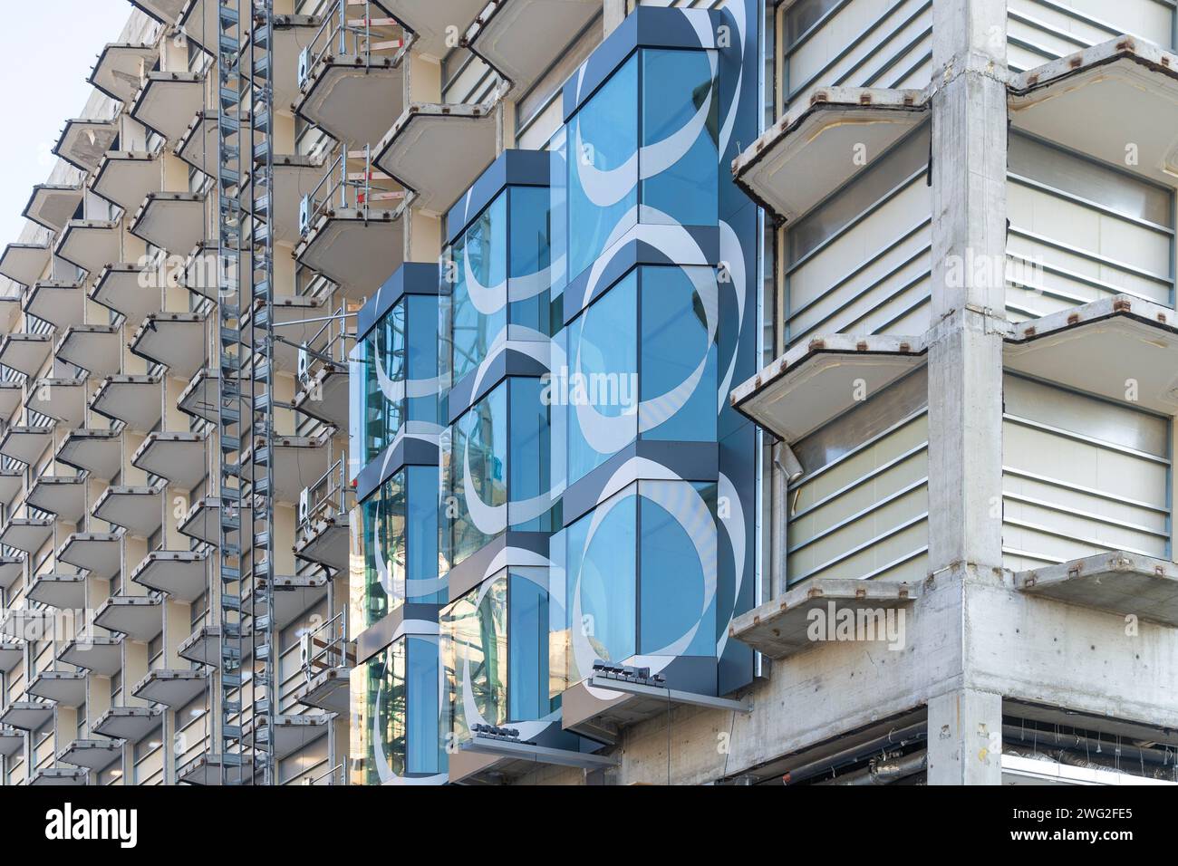 Ein Gebäude, das gerade renoviert wird, mit halbfertigen Betonbalkonen und Glasfenstern in Budapest Stockfoto