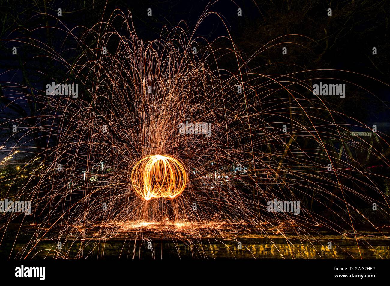 Ein faszinierendes Bild, das das wunderschöne Schauspiel des Feuers mit Feuerwerkskörpern in der Nähe des Wassers einfängt Stockfoto