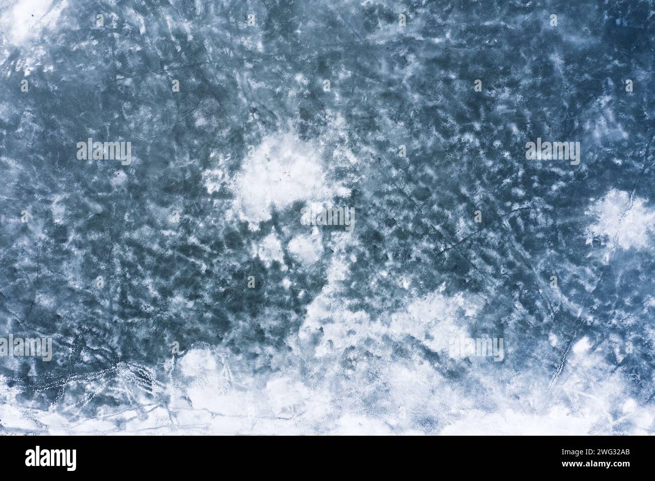 Hintergrund der gefrorenen See-Textur. Wasseroberfläche mit Eis und Schnee aus der Vogelperspektive bedeckt. Stockfoto