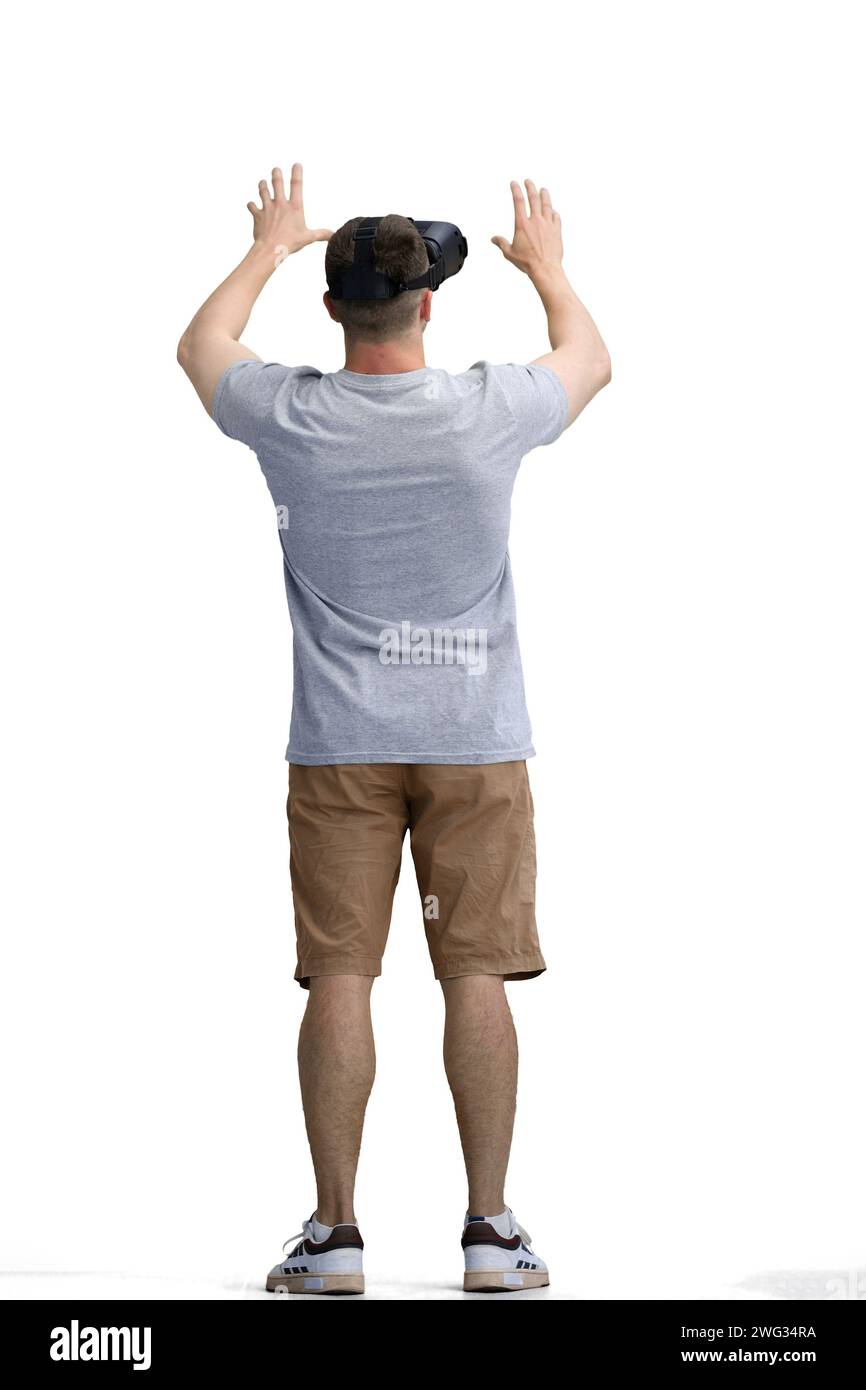 Ein Mann in einem grauen T-Shirt, auf weißem Hintergrund, in voller Länge, mit einer VR-Brille Stockfoto