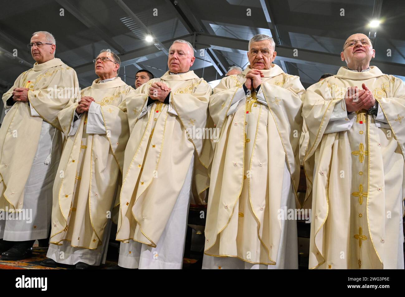 Katholische Priester in liturgischen Gewändern beten. Christliche Priester beten in der Kathedrale. Weihnachtsmesse Um Mitternacht Stockfoto