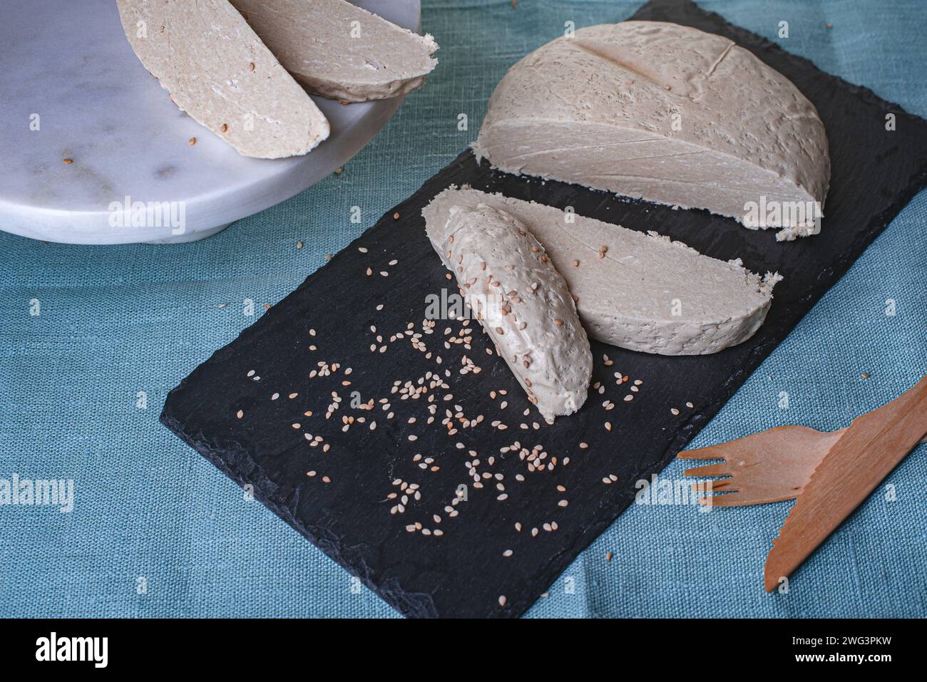 Sesamhalva auf schwarzem Steinbrett mit blauem Hintergrund. Stockfoto