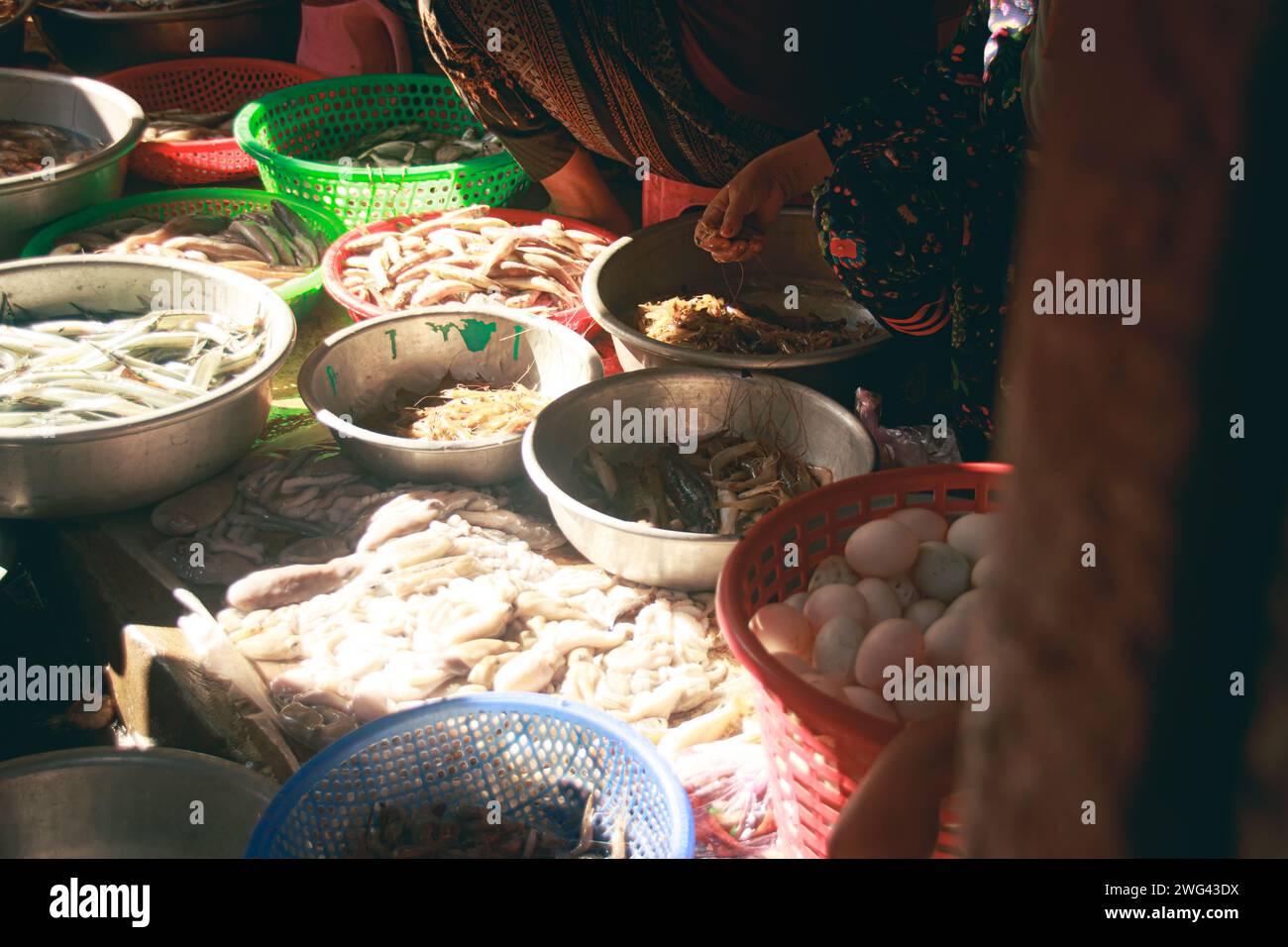 Verkäufer, der frische Meeresfrüchte auf dem lokalen traditionellen Samaki Nassmarkt in Kampot Kambodscha verkauft, authentischer ehrlicher Moment des täglichen Lebens und der Kultur der khmer Stockfoto