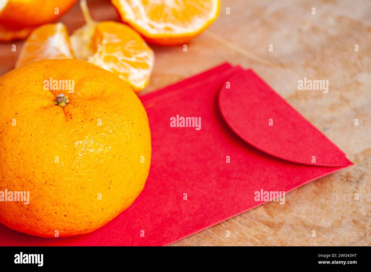 Mandarinorange auf dem roten chinesischen Neujahrspaket. Chinesisches Neujahrsfest. Stockfoto