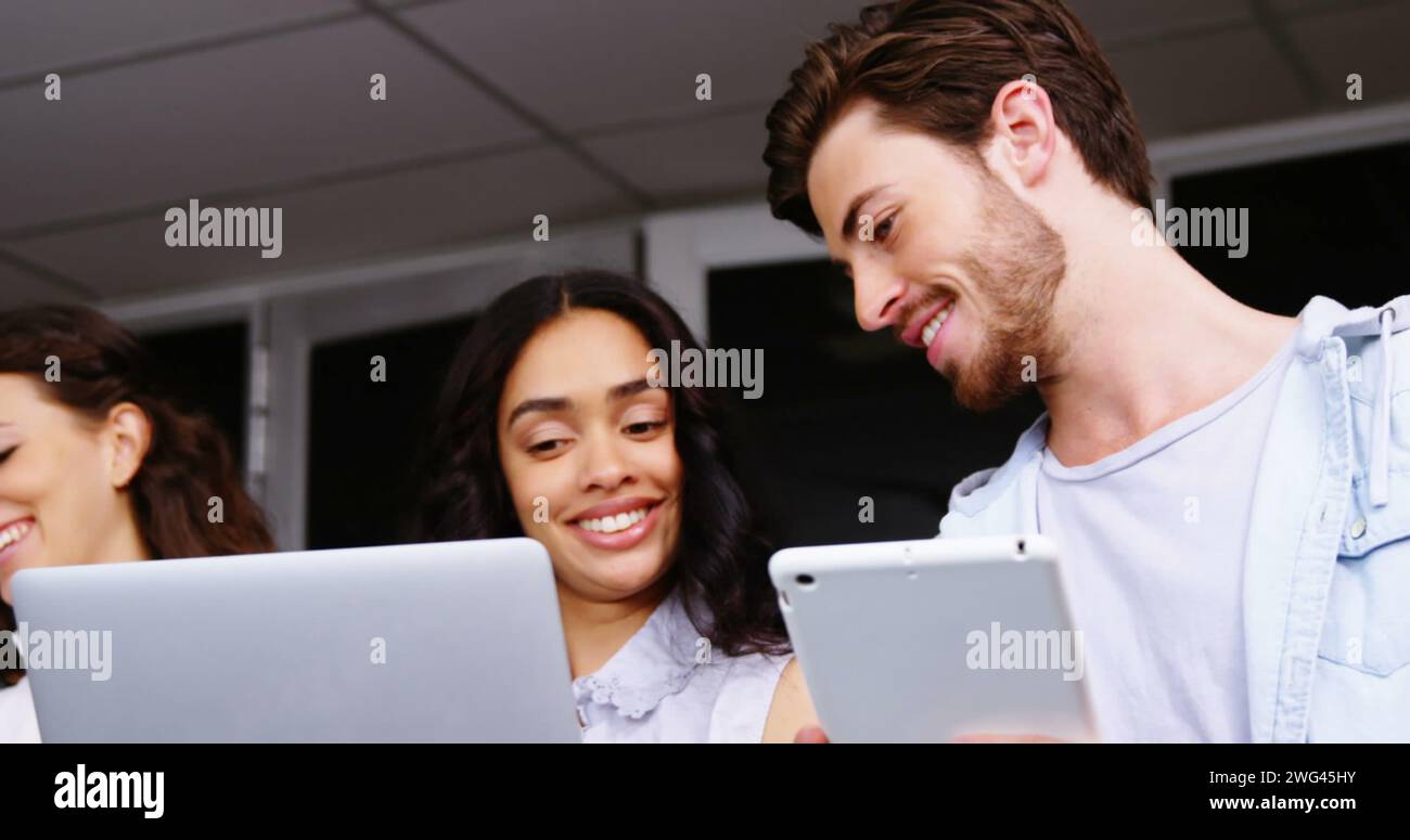 Junge kaukasische Frau und Mann teilen sich einen Moment im Büro Stockfoto