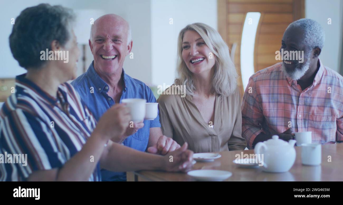 Eine Gruppe von Freunden lacht zu Hause über Kaffee Stockfoto