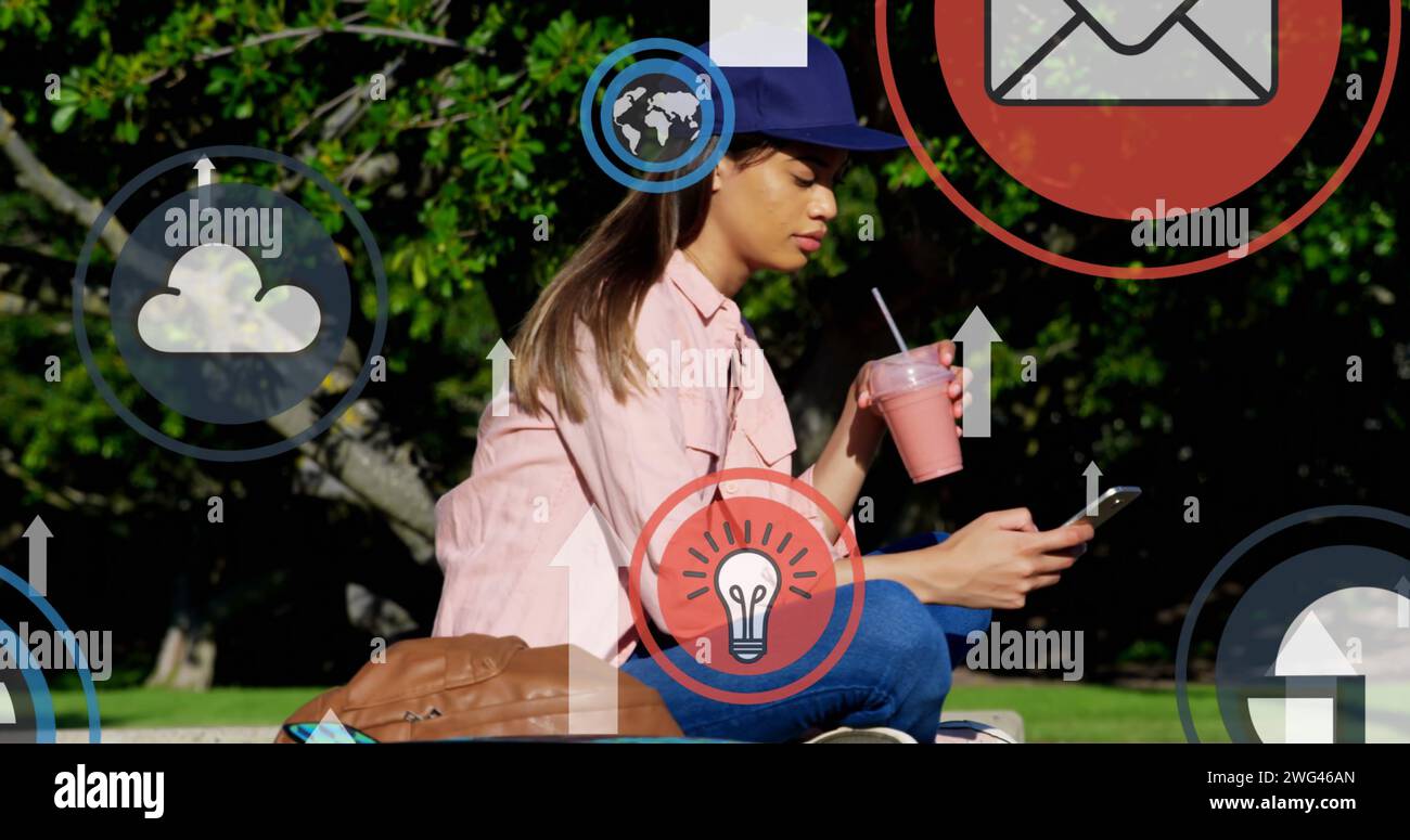 Digitale Symbole und Pfeile bewegen sich mit dem Smartphone im Park gegen die Frau Stockfoto