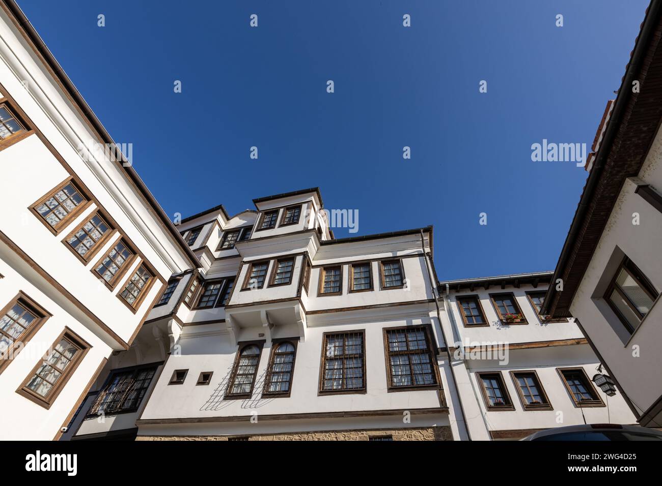 Traditionelle Architektur des alten Hauses in Ohrid in Nordmakedonien, mit Holzfenstern und weißer Fassade. Aufgenommen an einem sonnigen Tag mit blauem Himmel. Stockfoto