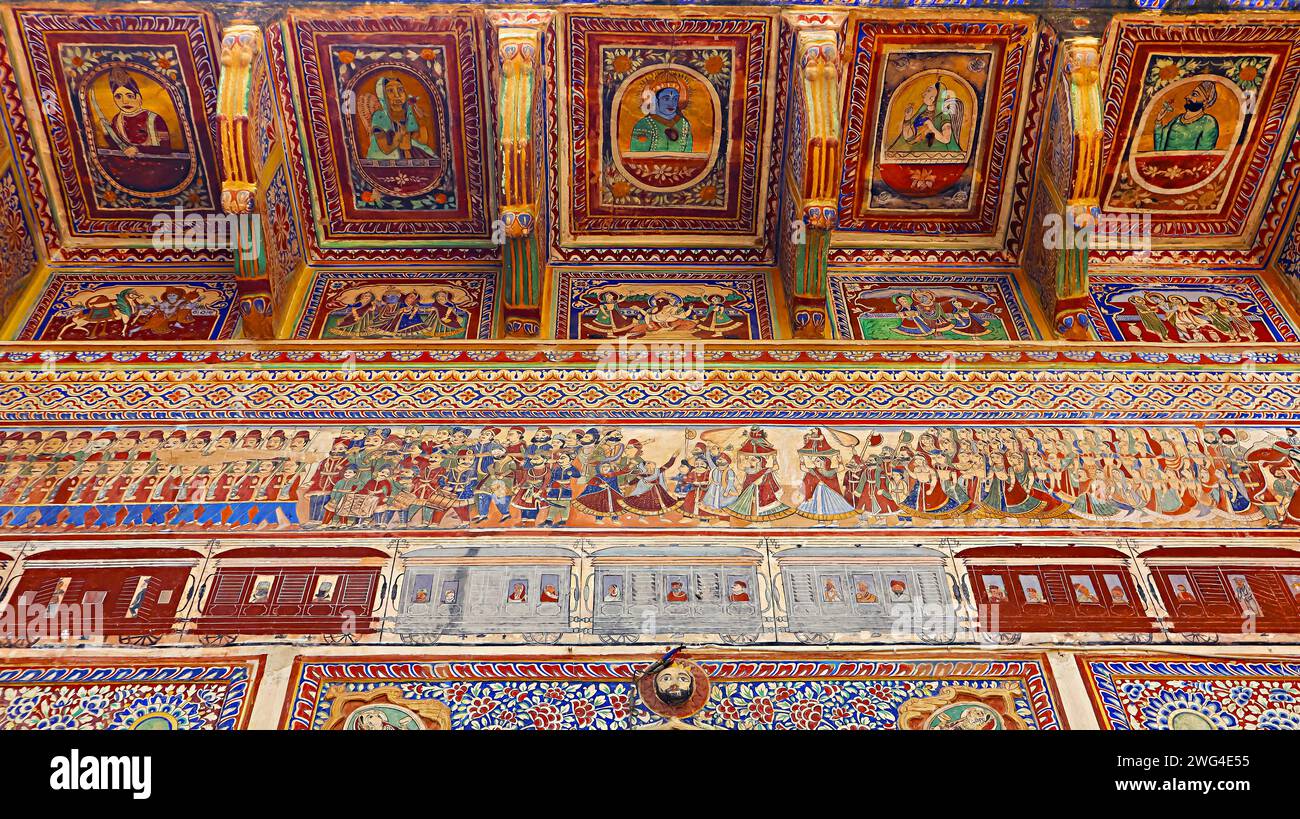 Gemälde von Zügen und Festivalfeiern an den Wänden des Dr. Ramnath Podar Haveli Museums, Nawalgarh, Rajasthan, Indien. Stockfoto