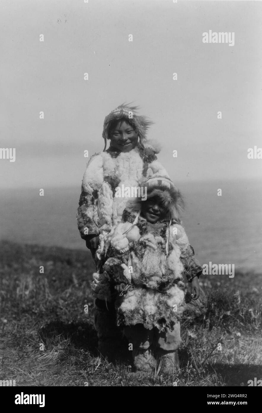 Entenleder-Parkas, Nunivak, 1929. Eskimo Erwachsene und Kind tragen Entenhautparkas. Stockfoto