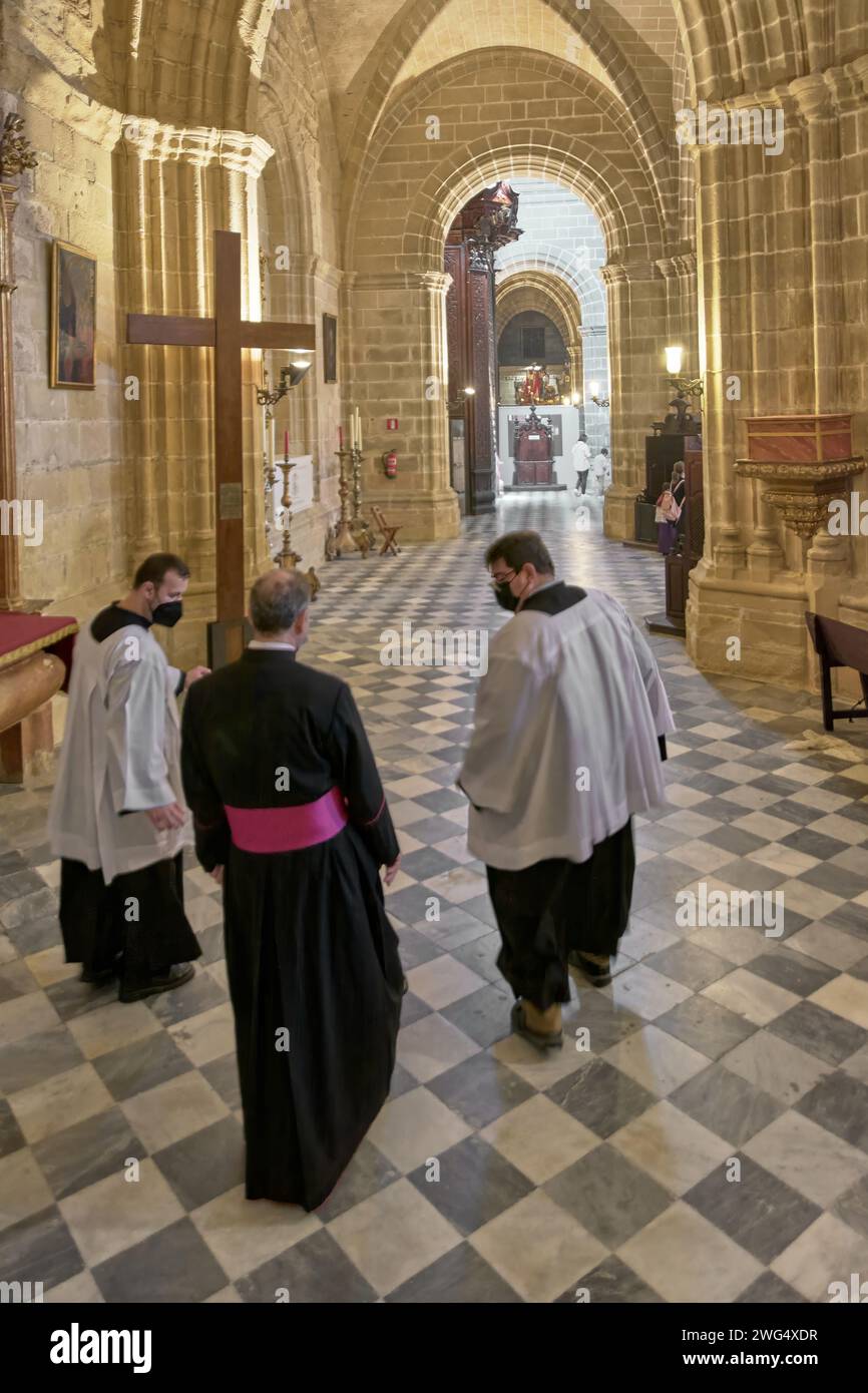 Jerez de la Frontera, Spanien - 3. Februar 2024: Geistlicher in der Kathedrale von Jerez de la Frontera, begleitet von zwei Altarjungen, die vorangehen Stockfoto