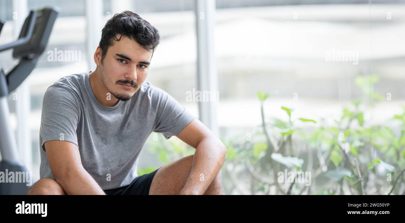 Zwangloser und entspannter junger Erwachsener, der seine Freizeit in einem modernen Fitnessstudio genießt. Stockfoto