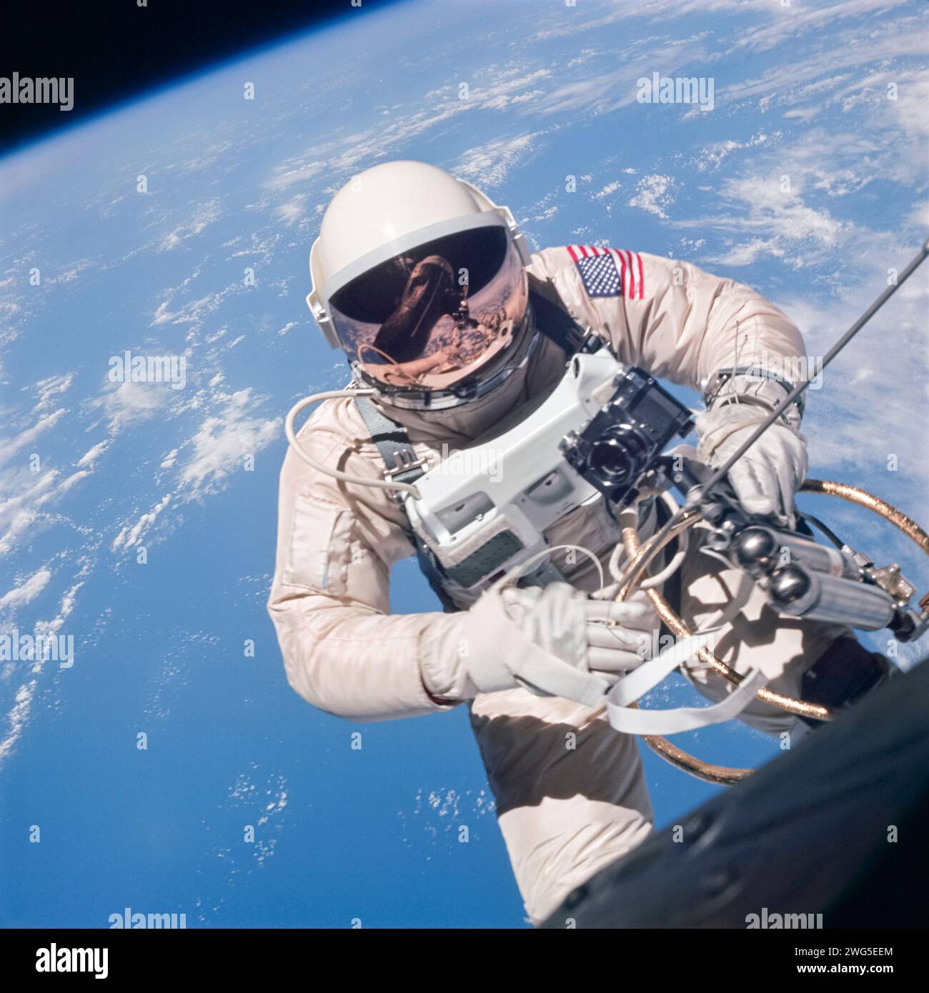 Gemini 4 Astronaut Ed White, der erste Amerikaner, der außerfahrbare Aktivitäten ausübt, schwimmt in der Schwerelosigkeit nordöstlich von Hawaii. An der Gemini 4-Kapsel mit einem goldenen Band und einer Handmanövriereinheit (HHSMU) in der rechten Hand befestigt. Dieses heute ikonische Foto wurde von dem Astronauten James McDivitt am 3. Juni 1965 aufgenommen. Stockfoto