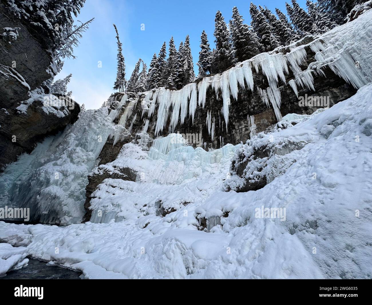 Eisfälle hängen in den Johnston Canyon Falls, einem Ort, an dem Touristen und Kletterer jedes Jahr vorbeikommen, in Banff, Kanada Stockfoto