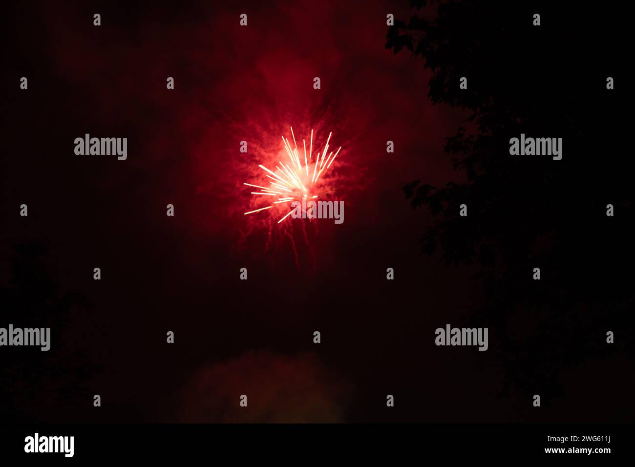 Rotes Feuerwerk in der Nacht - leuchtende rote Streifen und Funken - Rauchwolken - Feier, Neujahrstag, 4. juli, kanada-Tag. Aufgenommen in Tor Stockfoto