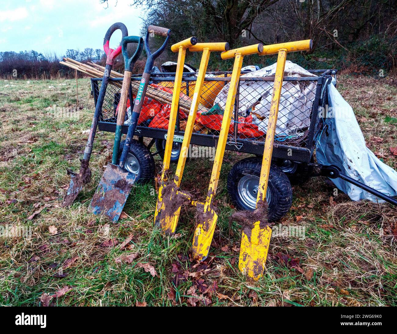Trailer mit Pik und Wurzeljägern, der auf einer Farm in Südwales Bäume pflanzte Stockfoto