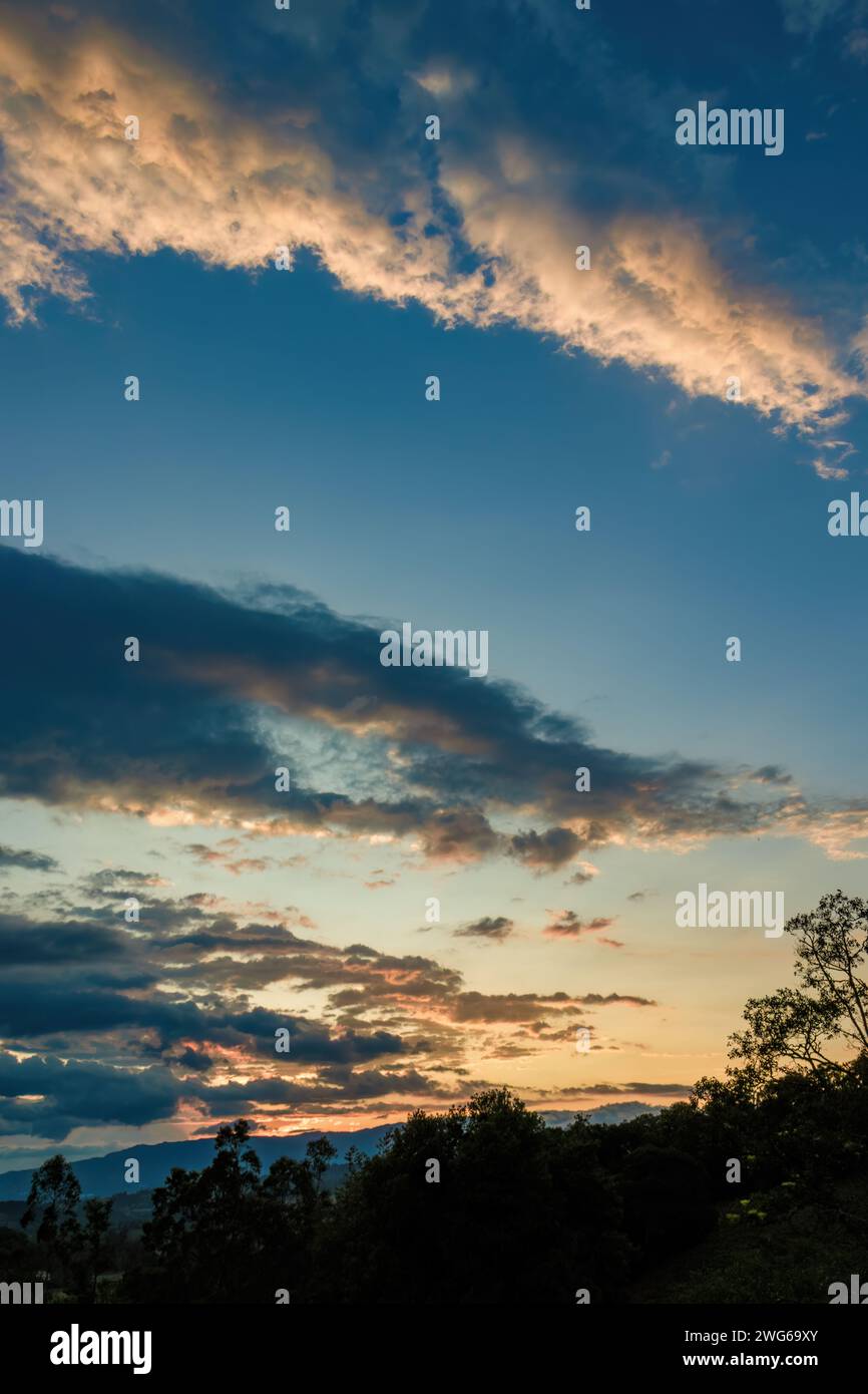 Panoramablick auf die Farben des Nachglühens, am Himmel über die Wälder und Ackerflächen der östlichen Anden in Zentral-Kolumbien. Stockfoto