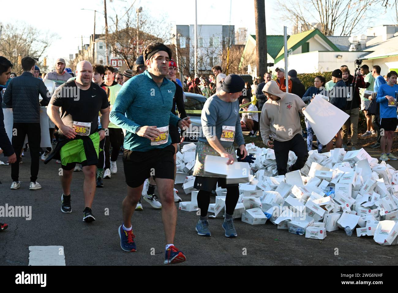 Raleigh, NC, USA, 3. Februar 2024. Knapp über 4.000 Läufer nahmen an der 20. Krispy Kreme Challenge Teil, einem 8-Meilen-Rennen, bei dem die Läufer anhalten, um ein Dutzend glasierte Donuts auf halbem Weg hinunter zu wölfen. Die Krispy Kreme Challenge, die 2004 erstmals als Wagen ausgetragen wurde, diente seitdem als Spendenaktion für das Kinderkrankenhaus der University of North Carolina und sammelte über 2 Millionen US-Dollar. Credit D Guest Smith / Alamy Live News Stockfoto