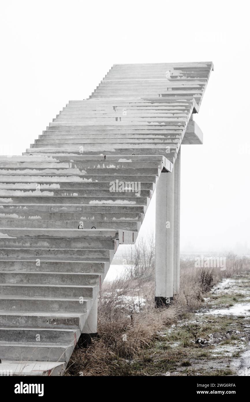Treppen ins Nirgendwo. Leere unfertige Bridge. Außentreppe ohne Ende Treppe zum Himmel. Brücke im Bau. Treppen gegen bewölkten Himmel Stockfoto