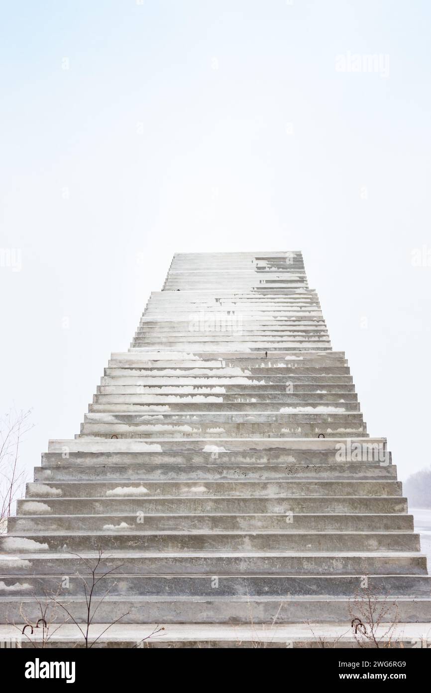 Treppen ins Nirgendwo. Leere unfertige Bridge. Außentreppe ohne Ende Treppe zum Himmel. Brücke im Bau. Treppen gegen bewölkten Himmel Stockfoto