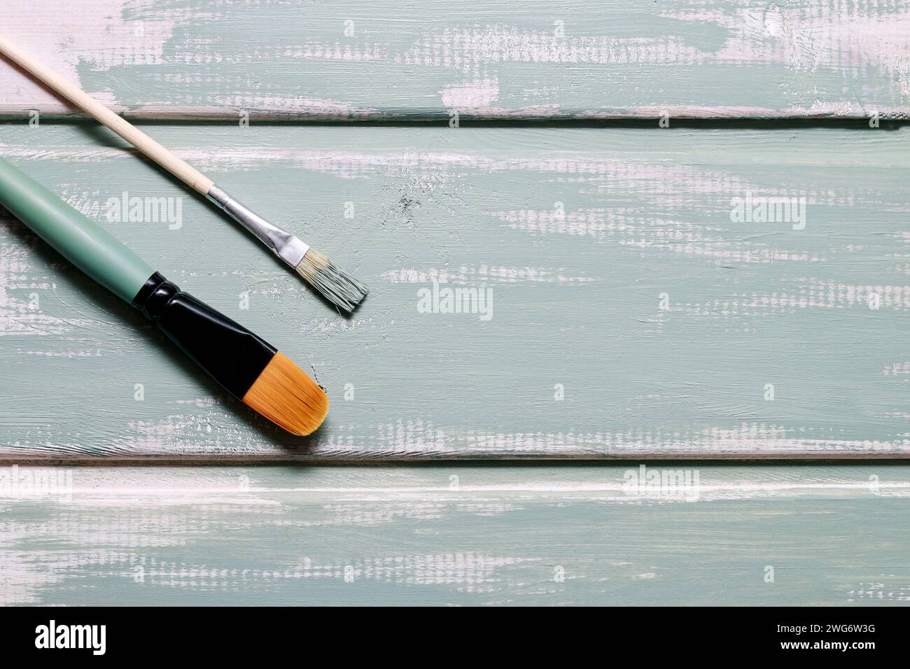 Zwei Bürsten und Minze Kreide Farbe auf Holzoberfläche, Textfreiraum Stockfoto