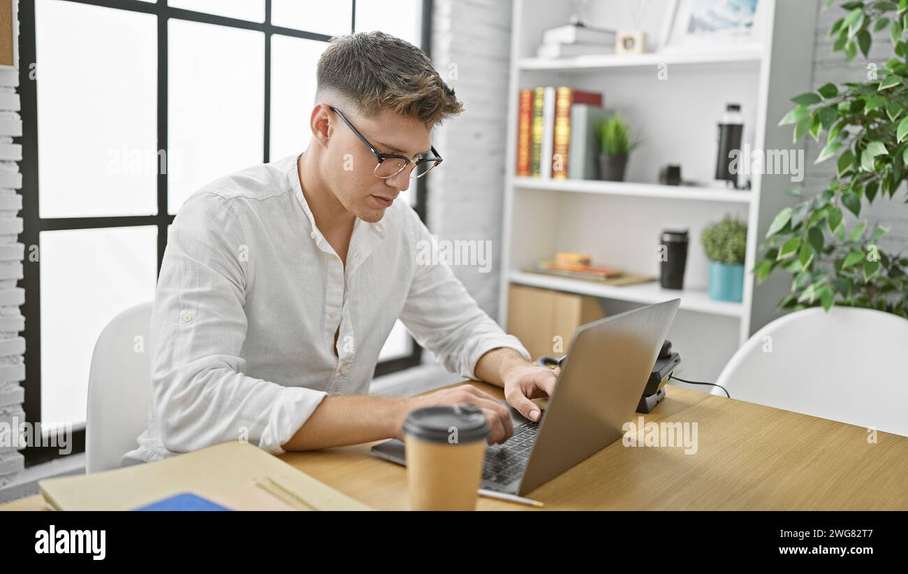 Hübscher junger kaukasier, konzentrierter Geschäftsmann, mühelos schaukelnder Erwachsenenbart, Online-Erfolg, ernstzunehmender Ernst in Bürozimmern Stockfoto