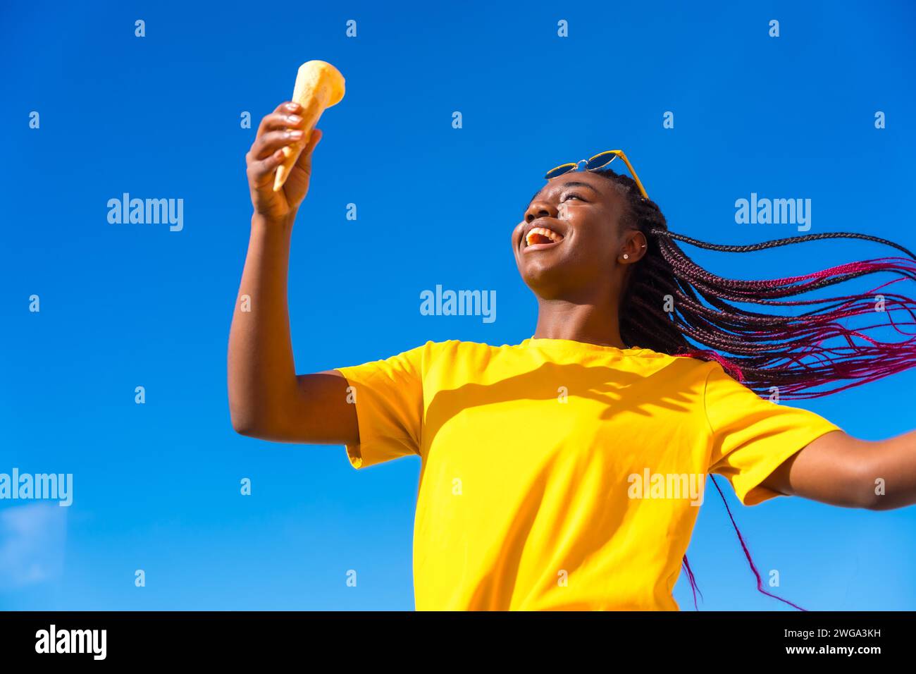 Tiefwinkelansicht einer glücklichen afrikanerin, die draußen ein Eis hält Stockfoto
