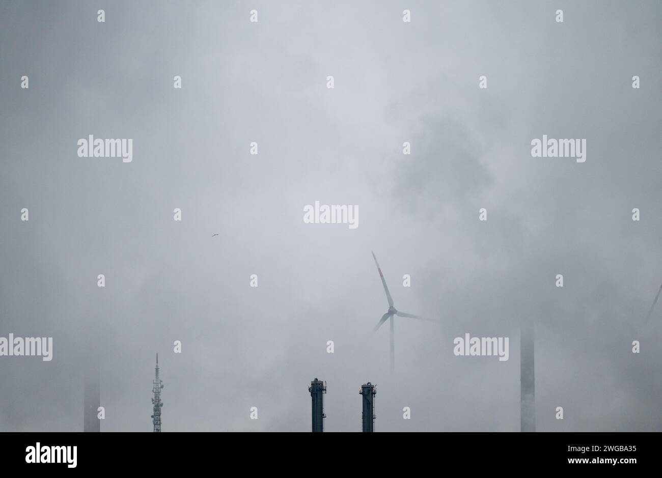 Oberhausen, Deutschland. Februar 2024. Blick auf die Schornsteine der Raffinerie Ruhr Oel GmbH - BP Gelsenkirchen am frühen Morgen mit Scholvener Schlacke und Windrädern im Hintergrund. BP betreibt eine komplexe Raffinerie und einen petrochemischen Standort in Gelsenkirchen Scholven. Quelle: Fabian Strauch/dpa/Alamy Live News Stockfoto