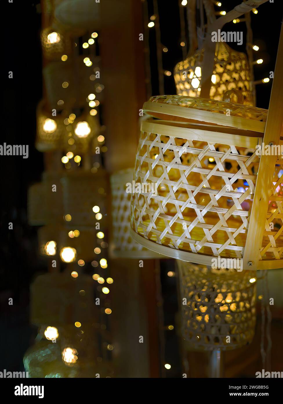 Nahaufnahme Bambus Weblampe, beleuchtete Lampe, dekoratives Produkt, Wohnkultur, lokales Handwerk, selektiver Fokus mit Bokeh-Hintergrund Stockfoto