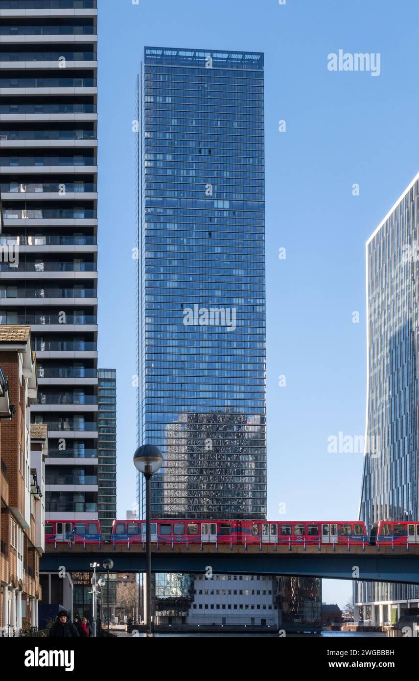 Der DLR Docklands Light Railway-Zug überquert die Brücke über das South Dock mit den Wolkenkratzern der Canary Wharf in East London, England, Großbritannien Stockfoto