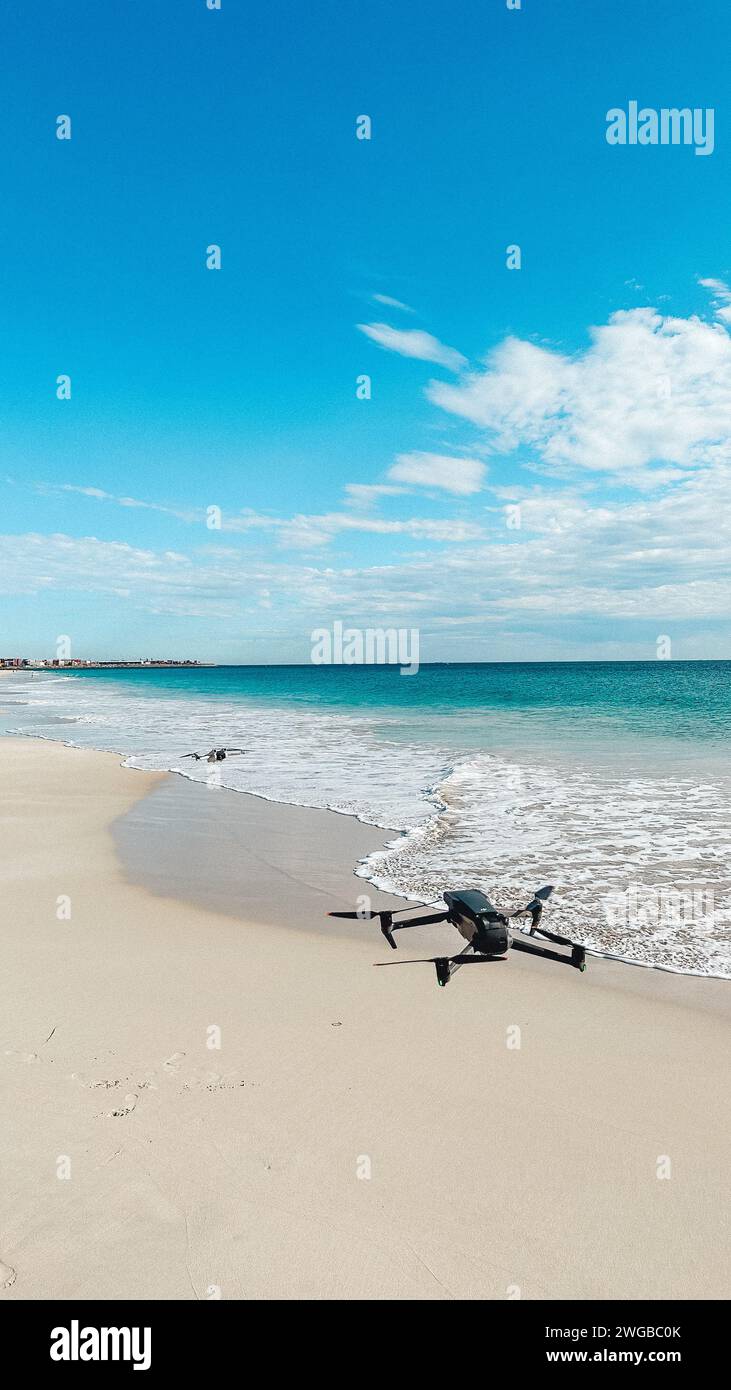 dji mavic 3 vs dji Mini 4 pro Drohne fliegt in der Luft am Strand mit Wellen weißen Sand perth australia Luftdrohne Stockfoto