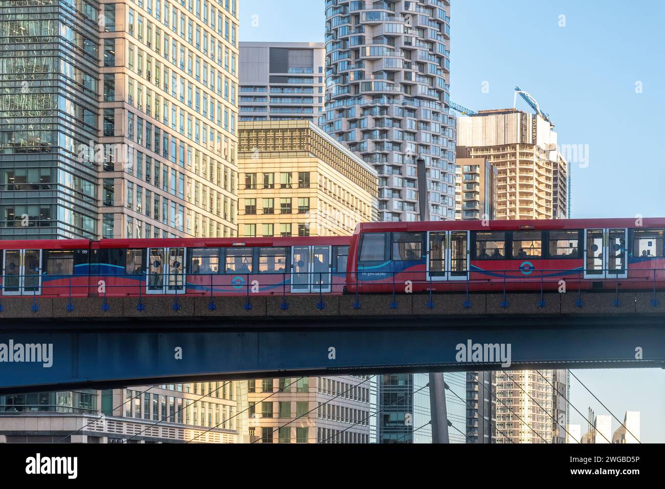 Die DLR Docklands Light Railway überquert die Brücke über das South Dock mit den Wolkenkratzern Canary Wharf in East London, England, Großbritannien Stockfoto