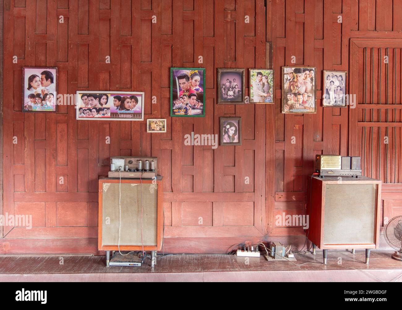 Inneneinrichtung des traditionellen thailändischen Holzhauses mit klassischer Stereo-hifi-anlage und Fotos thailändischer Berühmtheiten an der Wand. Stockfoto