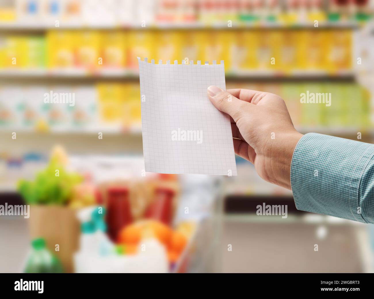 Eine Frau, die Lebensmittel im Supermarkt kauft, hat eine leere Einkaufsliste, ein Bild vom Standpunkt Stockfoto