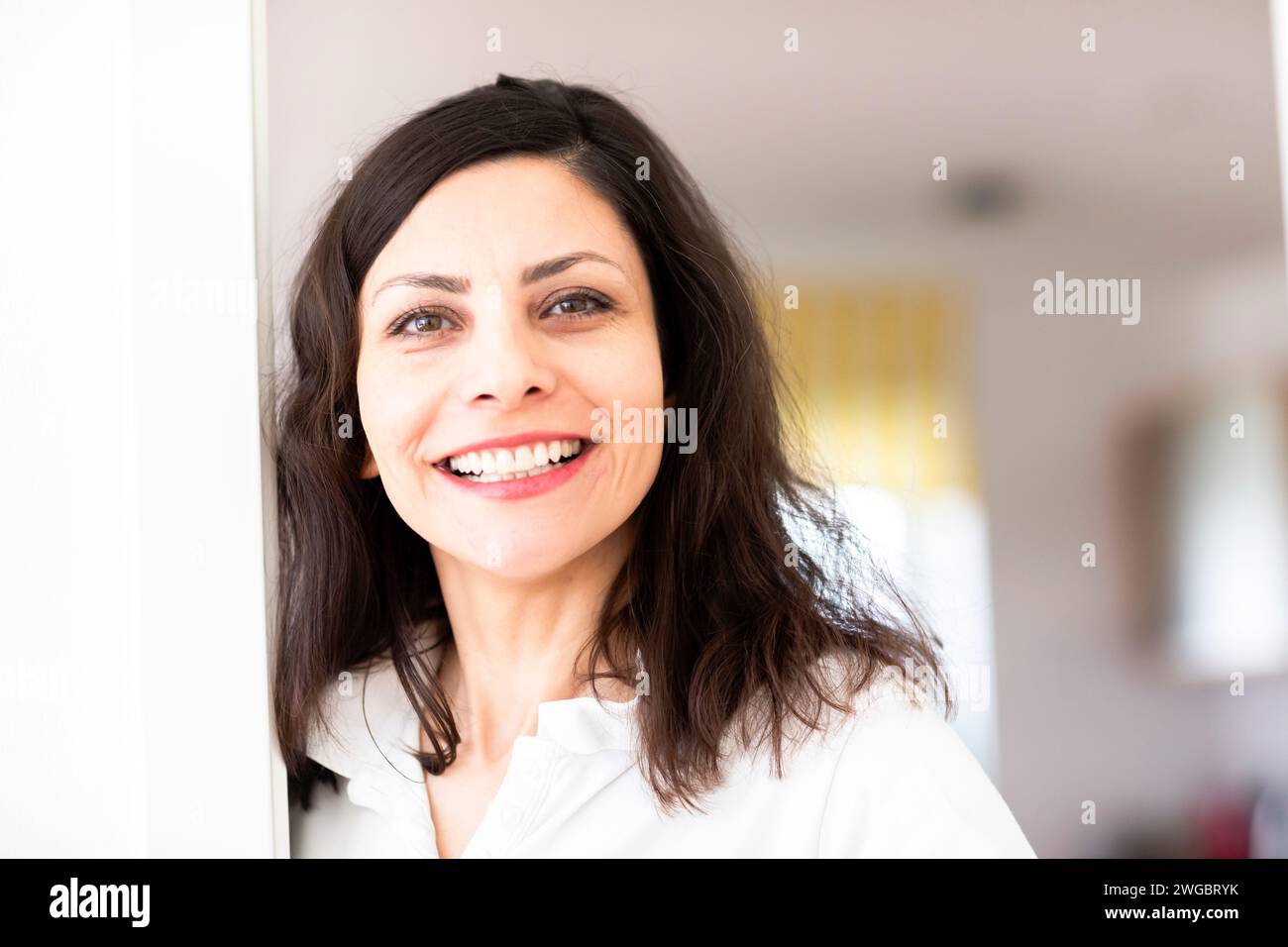 Porträt einer lächelnden Frau, die in ihrem Haus steht Stockfoto