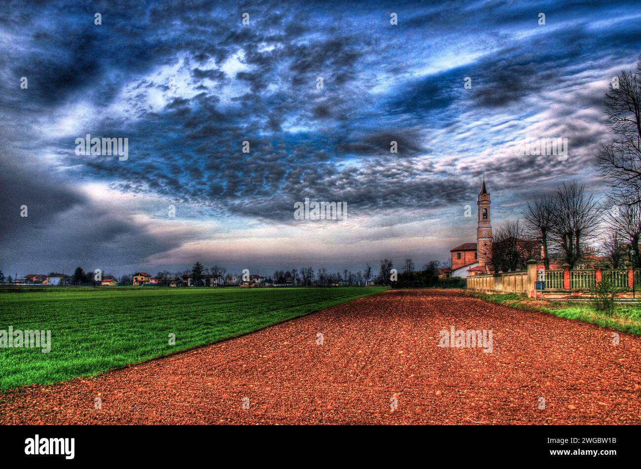 Dramatischer Himmel über Ackerland und Dorflandschaft, San Giuliano Nuovo, Alessandria, Piemont, Italien Stockfoto